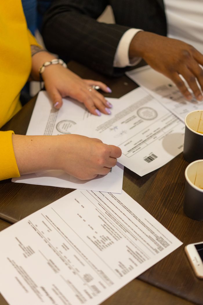 Home Multiracial colleagues collaborating in a business meeting, reviewing documents on a wooden table.